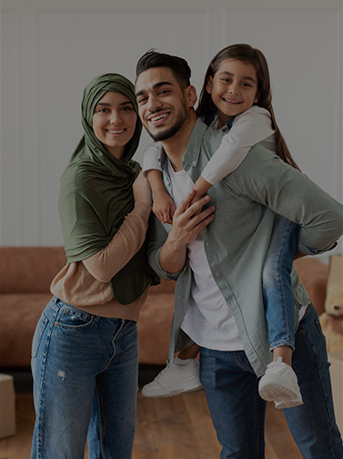 Mother and father with young girl riding on fathers back.