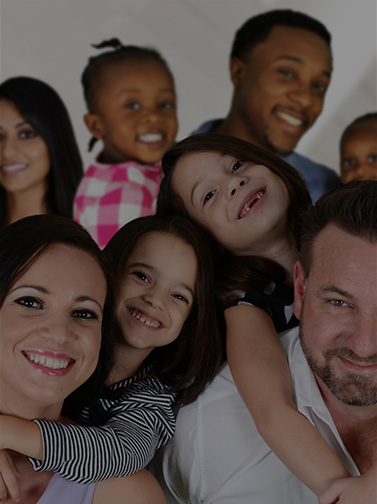 Multiple families of mixed race smiling playfully.