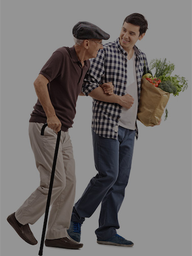 Young man carrying groceries assists older man with cane.