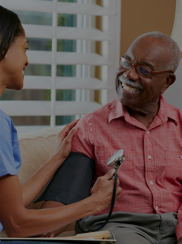 Medical professional tests blood pressure of elderly man.