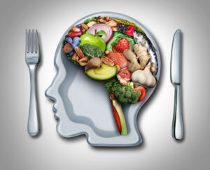 Assorted fruits and vegetables arranged in the shape of a brain placed inside a plate shaped like a head.