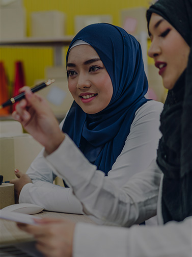 Two girls interacting with Zoom call on computer display.