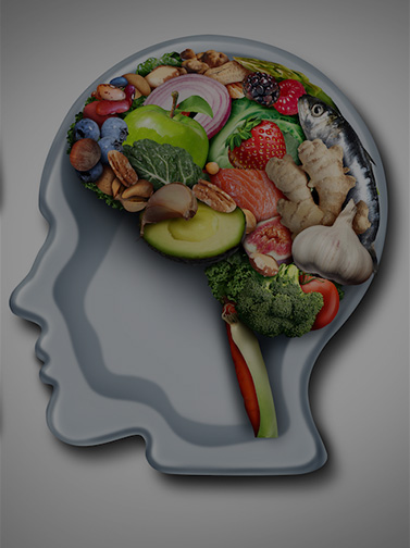 Assorted fruits and vegetables arranged in the shape of a brain placed inside a plate shaped like a head.