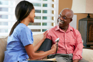 Medical professional tests blood pressure of elderly man.