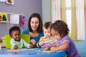 Early years education facilitator with three young pupils.