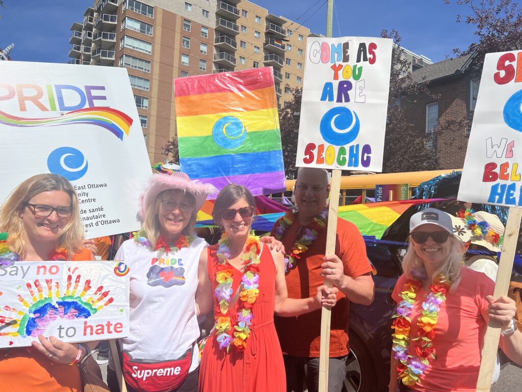men and women holding lgbtqia+ pride signs
