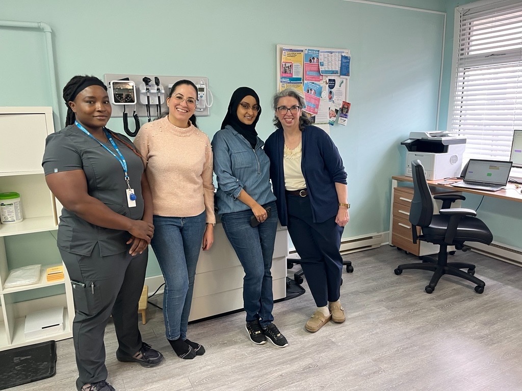 four medical professionals standing in medical examination room